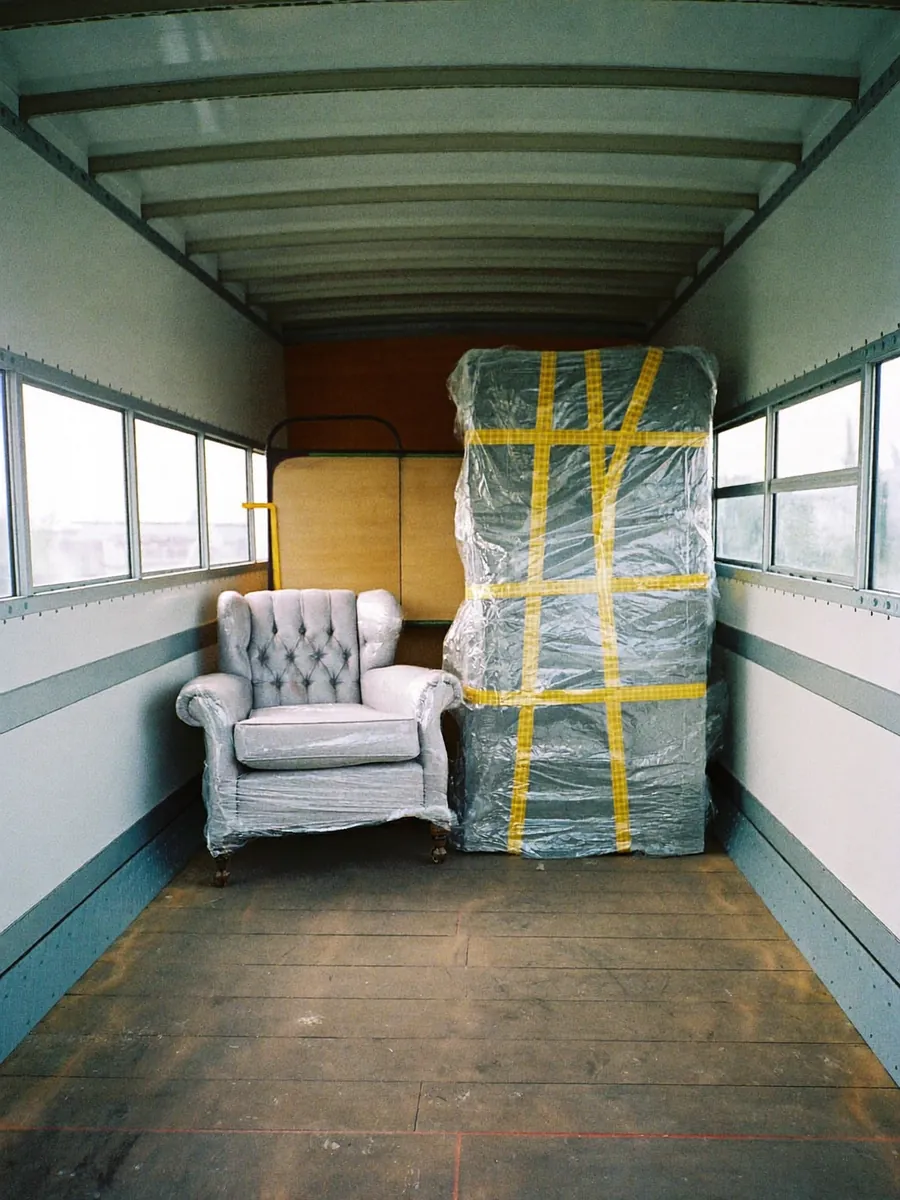 Un fauteuil et une commode protégés par des couvertures dans un camion